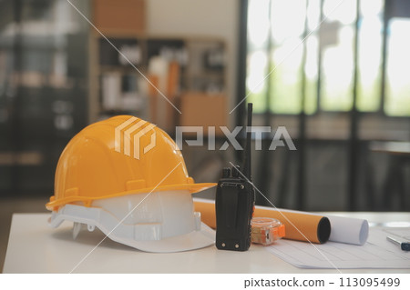 Male and Female Industrial Engineers in Hard Hats Discuss New Project while Using Laptop. They Make Showing Gestures.They Work in a Heavy Industry Manufacturing Factory. 113095499
