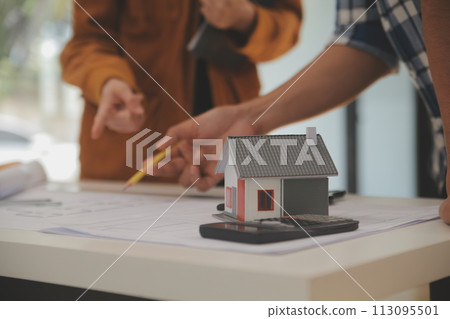Male and Female Industrial Engineers in Hard Hats Discuss New Project while Using Laptop. They Make Showing Gestures.They Work in a Heavy Industry Manufacturing Factory. 113095501