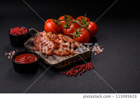 Delicious fresh fried bacon with salt and spices on a dark background Delicious fresh fried bacon with salt and spices on a dark background 113095628
