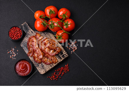 Delicious fresh fried bacon with salt and spices on a dark background Delicious fresh fried bacon with salt and spices on a dark background 113095629