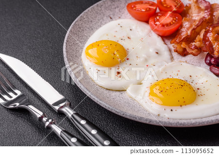 English breakfast with fried eggs, bacon, beans, tomatoes, spices and herbs English breakfast with fried eggs, bacon, beans, tomatoes, spices and herbs 113095652