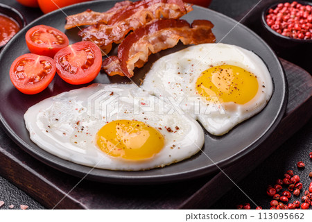 English breakfast with fried eggs, bacon, beans, tomatoes, spices and herbs English breakfast with fried eggs, bacon, beans, tomatoes, spices and herbs 113095662