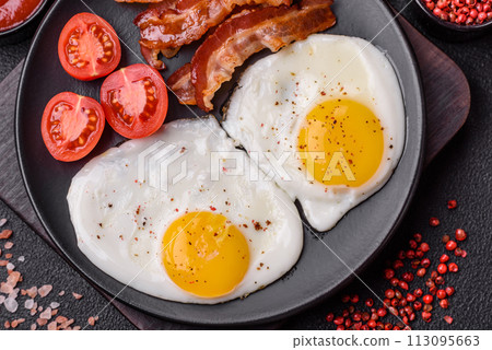English breakfast with fried eggs, bacon, beans, tomatoes, spices and herbs English breakfast with fried eggs, bacon, beans, tomatoes, spices and herbs 113095663