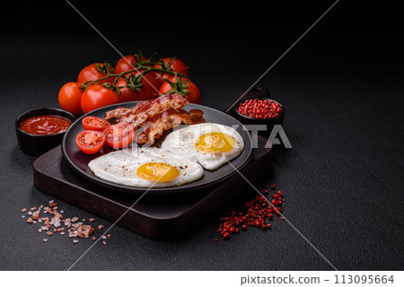 English breakfast with fried eggs, bacon, beans, tomatoes, spices and herbs English breakfast with fried eggs, bacon, beans, tomatoes, spices and herbs 113095664