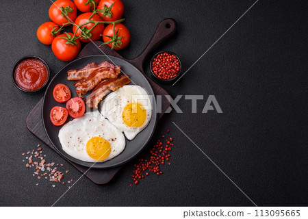 English breakfast with fried eggs, bacon, beans, tomatoes, spices and herbs English breakfast with fried eggs, bacon, beans, tomatoes, spices and herbs 113095665