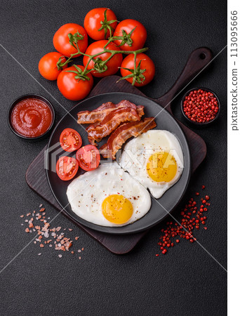 English breakfast with fried eggs, bacon, beans, tomatoes, spices and herbs English breakfast with fried eggs, bacon, beans, tomatoes, spices and herbs 113095666