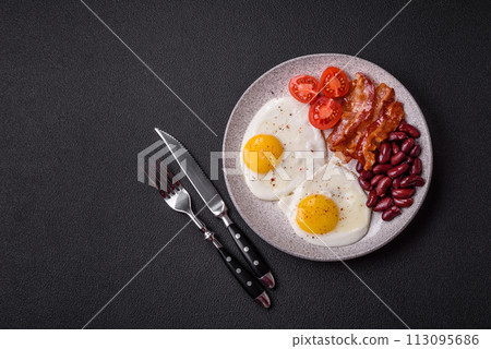 English breakfast with fried eggs, bacon, beans, tomatoes, spices and herbs English breakfast with fried eggs, bacon, beans, tomatoes, spices and herbs 113095686