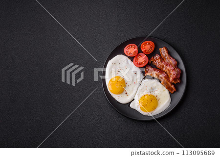 English breakfast with fried eggs, bacon, beans, tomatoes, spices and herbs English breakfast with fried eggs, bacon, beans, tomatoes, spices and herbs 113095689