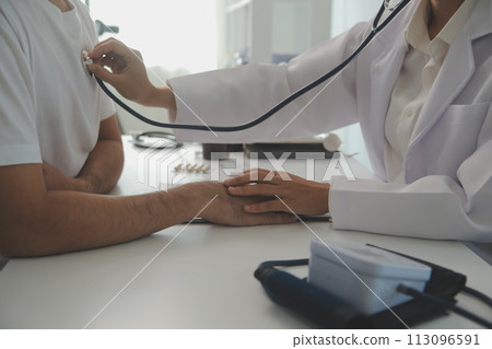 Young doctor is using a stethoscope listen to the heartbeat of the patient. Shot of a female doctor giving a male patient a check up 113096591