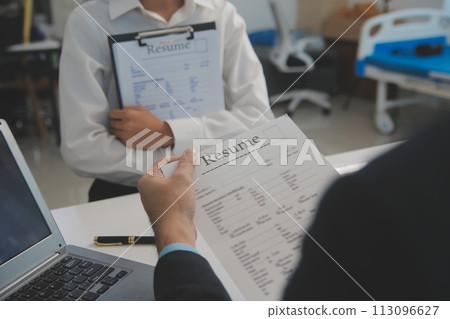 Close up view of job interview in office, focus on resume writing tips, employer reviewing good cv of prepared skilled applicant, recruiter considering application, hr manager making hiring decision Close up view of job interview in office, focus on resume writing tips, employer reviewing good cv of prepared skilled applicant, recruiter considering application, hr manager making hiring decision 113096627