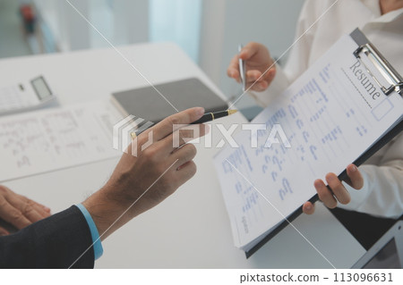 Close up view of job interview in office, focus on resume writing tips, employer reviewing good cv of prepared skilled applicant, recruiter considering application, hr manager making hiring decision Close up view of job interview in office, focus on resume writing tips, employer reviewing good cv of prepared skilled applicant, recruiter considering application, hr manager making hiring decision 113096631
