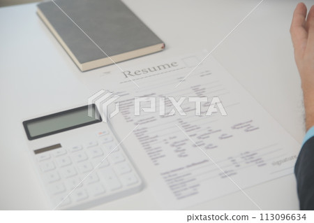 Close up view of job interview in office, focus on resume writing tips, employer reviewing good cv of prepared skilled applicant, recruiter considering application, hr manager making hiring decision Close up view of job interview in office, focus on resume writing tips, employer reviewing good cv of prepared skilled applicant, recruiter considering application, hr manager making hiring decision 113096634
