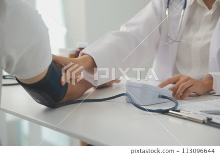 Male doctor uses a blood pressure monitor to check the body pressure and pulse of the patients who come to the hospital for check-ups, Medical treatment and health care concept. Male doctor uses a blood pressure monitor to check the body pressure and pulse of the patients who come to the hospital for check-ups, Medical treatment and health care concept. 113096644