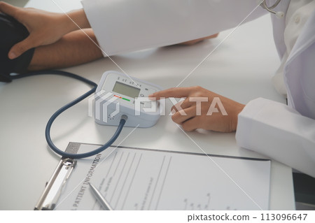 Male doctor uses a blood pressure monitor to check the body pressure and pulse of the patients who come to the hospital for check-ups, Medical treatment and health care concept. Male doctor uses a blood pressure monitor to check the body pressure and pulse of the patients who come to the hospital for check-ups, Medical treatment and health care concept. 113096647