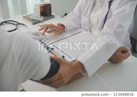 Male doctor uses a blood pressure monitor to check the body pressure and pulse of the patients who come to the hospital for check-ups, Medical treatment and health care concept. Male doctor uses a blood pressure monitor to check the body pressure and pulse of the patients who come to the hospital for check-ups, Medical treatment and health care concept. 113096656