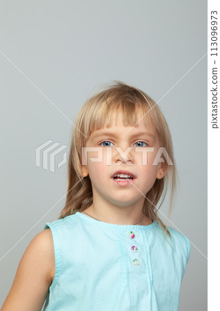 Pensive little girl against a grey background Pensive little girl against a grey background 113096973