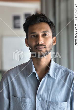 Serious attractive Indian man posing for vertical head shot Serious attractive Indian man posing for vertical head shot 113097174