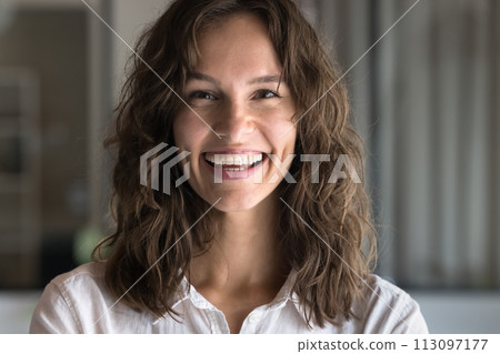Happy young Caucasian woman with wavy hair looking at camera Happy young Caucasian woman with wavy hair looking at camera 113097177