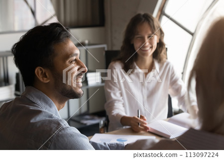 Cheerful young Indian business professional man enjoying corporate communication 113097224