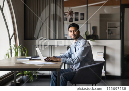 Professional portrait of young Indian business man working at computer Professional portrait of young Indian business man working at computer 113097286