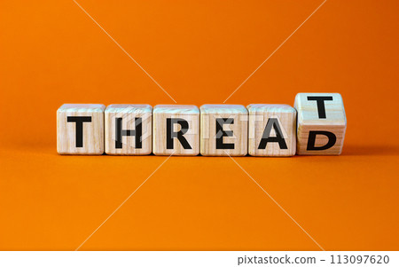 Symbol for online hate. Turned a cube and changed the word 'threat' to 'thread'. Beautiful orange background. Concept. Copy space. Symbol for online hate. Turned a cube and changed the word 'threat' to 'thread'. Beautiful orange background. Concept. Copy space. 113097620