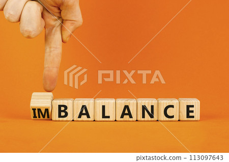 Balance or imbalance symbol. Concept word Imbalance or Balance on beautiful wooden cubes. Beautiful orange background. Businessman hand. Business balance or imbalance concept. Copy space. Balance or imbalance symbol. Concept word Imbalance or Balance on beautiful wooden cubes. Beautiful orange background. Businessman hand. Business balance or imbalance concept. Copy space. 113097643