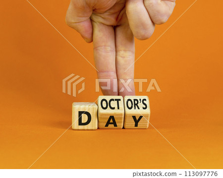 Doctor day symbol. Doctor turns wooden cubes with words 'Doctors day'. Beautiful orange background. Doctor day and medical concept. Copy space. 113097776