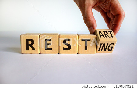Symbol for the end of the quarantine period. Male hand flips a wooden cube and changes the inscription 'resting' to 'restart'. Beautiful white background, copy space. Business concept. Symbol for the end of the quarantine period. Male hand flips a wooden cube and changes the inscription 'resting' to 'restart'. Beautiful white background, copy space. Business concept. 113097821
