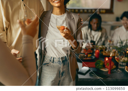 Close up of friends enjoying in conversation and drinking wine during holiday party at home Close up of friends enjoying in conversation and drinking wine during holiday party at home 113099850