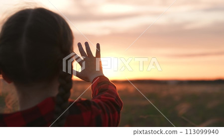 Girl dreamily reaches for sun with hand. Symbolism striving for light wisdom spiritual enlightenment knowledge self-development aspirations. Expectation of miracle dreams inspiration of young child. Girl dreamily reaches for sun with hand. Symbolism striving for light wisdom spiritual enlightenment knowledge self-development aspirations. Expectation of miracle dreams inspiration of young child. 113099940