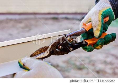 Sheet metal shears cut edge of window slope when installing trim of window opening from facade side. 113099962