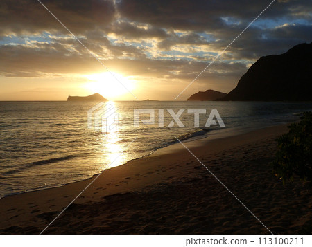 Early Morning Sunrise on Waimanalo Beach over Rabbit Island bursting through the clouds Early Morning Sunrise on Waimanalo Beach over Rabbit Island bursting through the clouds 113100211