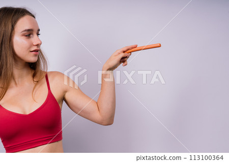 Close-up of a woman eating a sausage. Cropped photo in studio Close-up of a woman eating a sausage. Cropped photo in studio 113100364