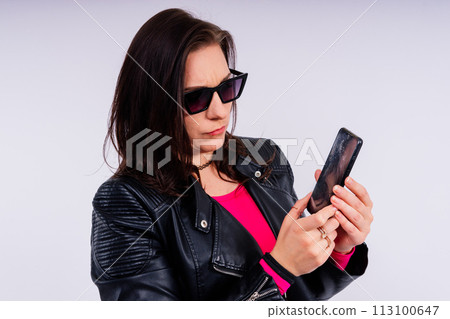 A frustrated young woman with a broken phone in her hands. White isolated background. Broken Gadget 113100647
