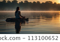 Woman meditating in the orange sunset 113100652
