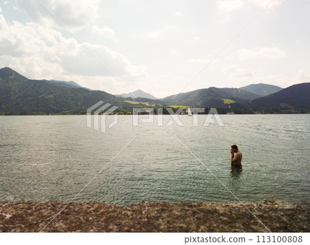 man swimming on the Turano lake during summer vacation. silueete mans 113100808