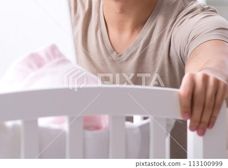 Young dad student preparing for exams and looking after baby 113100999