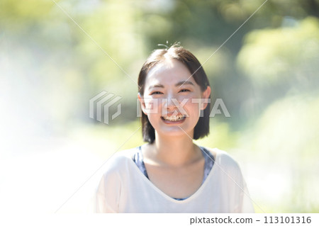 Smiling young woman running in sportswear 113101316