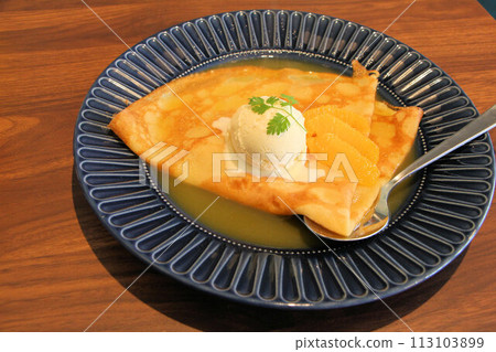 Delicious hot crepes, orange suzette and orange butter sauce dessert in a stylish cafe 113103899