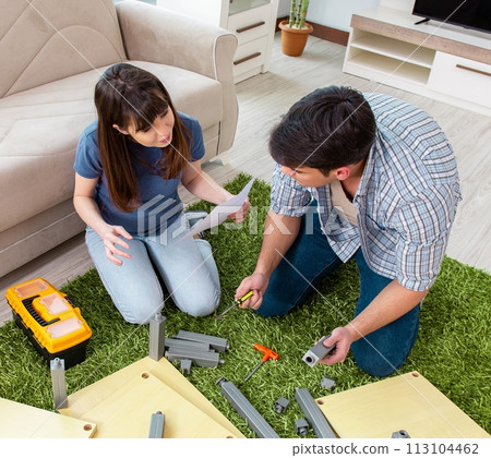 Young family assembling furniture at new house Young family assembling furniture at new house 113104462