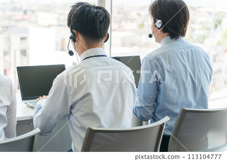 Male telephone operator answering calls at a call center Male telephone operator answering calls at a call center 113104777