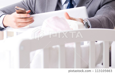 Young businessman trying to work from home caring after newborn 113105663