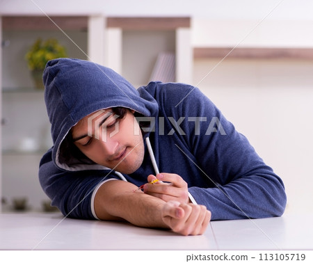 Young man having problems with narcotics at home Young man having problems with narcotics at home 113105719