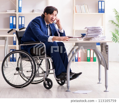 Young male employee in wheelchair working in the office 113105759