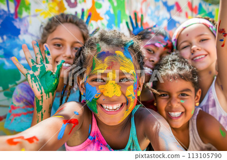 Children of diverse backgrounds painting a large mural together. 113105790