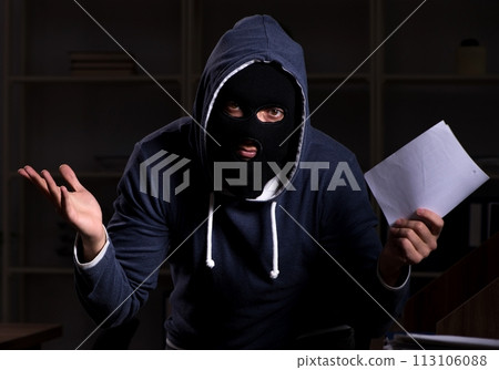 Male thief in balaclava in the office night time Male thief in balaclava in the office night time 113106088