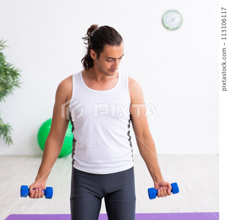 Young handsome man doing sport exercises indoors Young handsome man doing sport exercises indoors 113106117