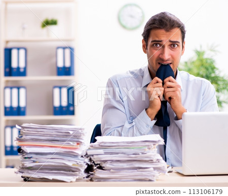 Young male employee unhappy with excessive work Young male employee unhappy with excessive work 113106179