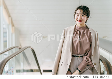 Business woman on a business trip climbing up the escalator at the airport/station (commuting/commuting) 113106445