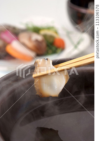 Abalone fillet held up with chopsticks, image of abalone shabu-shabu, image of steaming abalone shabu-shabu 113106578